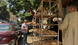 People queue outside a bakery to buy government-subsidised traditional pita bread in Cairo on August 17, 2026. Photo by Khaled Desouki / AFP

