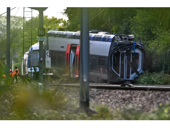 SNCF workers stand next to a derailed train carriage in Cléon, northwestern France, on September 12, 2026, the morning after the train derailed. (Photo by Guillaume Saligot / AFP)