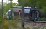 SNCF workers stand next to a derailed train carriage in Cléon, northwestern France, on September 12, 2026, the morning after the train derailed. (Photo by Guillaume Saligot / AFP)
