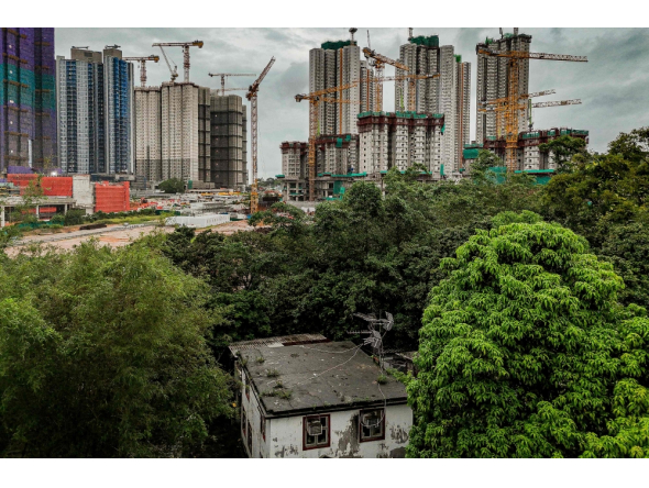 An aerial view shows the home of Kwu Tung resident Niki So in the foreground, as surrounding land is transformed into construction sites under Hong Kong's Northern Metropolis development plan, in Hong Kong, on June 17, 2026. (Photo by Leung Man Hei / AFP)