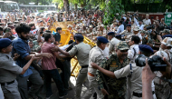 Protesters and All India Students' Association (AISA) supporters scuffle with police personnel during a demonstration against India's Chief Election Commissioner Gyanesh Kumar in New Delhi on October 3, 2026, to demand his resignation over alleged irregularities in the Special Intensive Revision (SIR) of electoral rolls. (Photo by Arun SANKAR / AFP)
