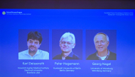 Screen displays portraits of (L-R) US scientist Karl Deisseroth and German scientists Peter Hegemann and Georg Nagel during the announcement of the winners of the 2026 Nobel Prize in Physiology or Medicine at the Karolinska Institute in Stockholm, Sweden, on October 5, 2026. Photo by Jonathan Nackstrand / AFP