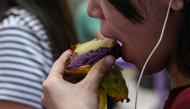 This photo taken on September 23, 2026 shows a customer eating an ube bibingka (baked rice cake) at a mall in Quezon City, Metro Manila. (Photo by Jam Sta Rosa / AFP) 