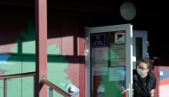 A security person wearing a face mask looks out from the door of an infectious diseases hospital in the town of Shelekhov, where an employee of the Irkutsk Antiplague Research Institute had died, in the Irkutsk region on October 7, 2026. (Photo by TATYANA MAKEYEVA / AFP)
