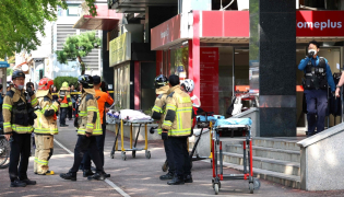Police officers and firefighters arrive at the scene after a stabbing incident at a supermarket in Incheon on October 13, 2026. (Photo by YONHAP / AFP) 