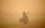 A person takes photos amid thick haze caused by forest and peatland fires in Palangka Raya, Central Kalimantan, Indonesia, Oct. 13, 2026. (Photo by Regina Safri/Xinhua)