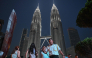 People walk past the Petronas Tower in Kuala Lumpur on October 18, 2026. (Photo by Jam STA ROSA / AFP)