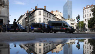 French Republican Security Corps (CRS - Compagnies Republicaines de Securite) police officers stand next to the Bourse du Travail where high school students, National Union of Students of France (UNEF) and the New Anticapitalist Party (NPA) gather for a general assembly, in Lyon on October 22, 2026. (Photo by Alex MARTIN / AFP)