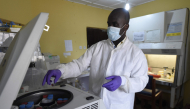 (FILES) A health official works in the laboratory extraction room of the Institute of Lassa Fever Research and Control in Irrua Specialist Teaching Hospital in Irrua, Edo State, midwest Nigeria, on March 6, 2018. (Photo by PIUS UTOMI EKPEI / AFP)