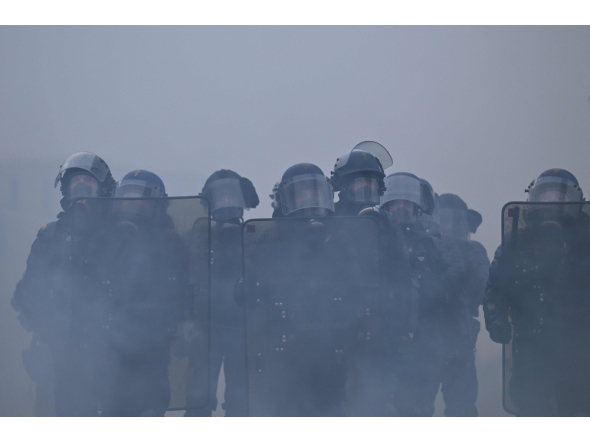 French gendarmes stand amidst tear gas during a demonstration in favor of purchasing power, the protection of public services, and fiscal and social justice, in Nantes, western France on October 24, 2026 (Photo by Guillaume Saligot / AFP)