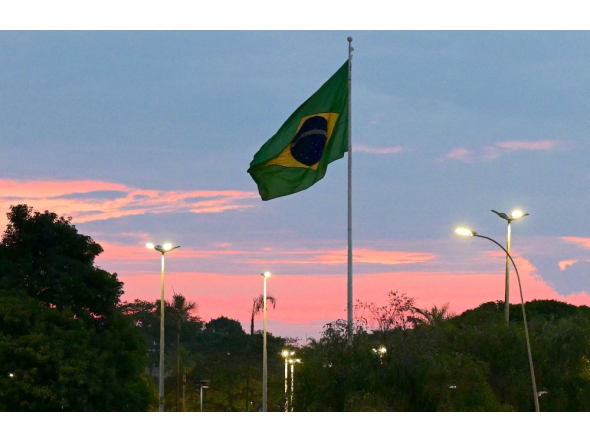 A Brazilian flag flies at sunset in Brasilia on October 24, 2026. (Photo by Pablo Porciuncula / AFP)