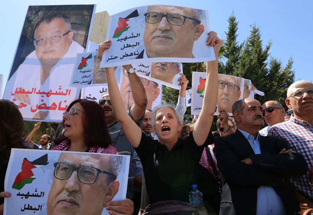 Protesters shout slogans and hold portraits of prominent Jordanian writer Nahed Hattar, who was shot dead the previous day outside an Amman court, during a demonstration in front of the prime minister's offices on September 26, 2016.  AFP / Khalil MAZRAAW