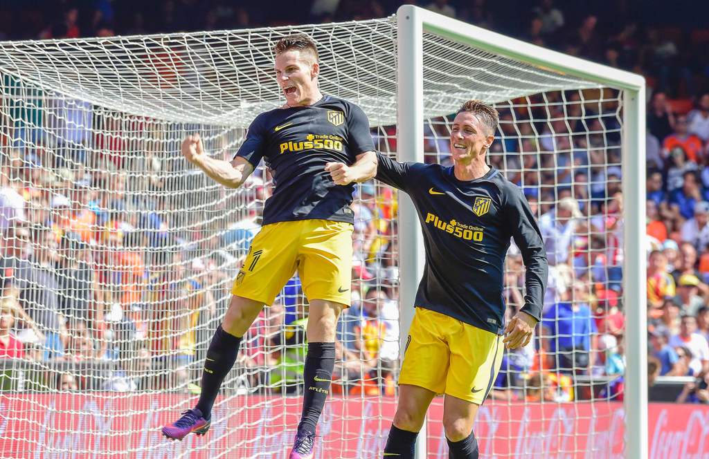 Atletico Madrid's French forward Kevin Gameiro (L) celebrates a goal with Atletico Madrid's forward Fernando Torres during the Spanish league football match Valencia FC vs Club Atletico de Madrid at Mestalla stadium in Valencia on October 2, 2016. / AFP /