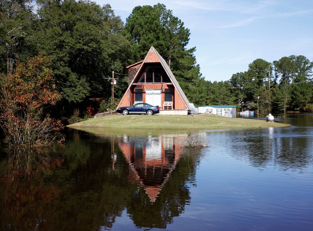 A home and vehicle share a temporary island as flood waters from the swollen Tar River inundate communities along its course in the aftermath of Hurricane Matthew, in Old Sparta, North Carolina, U.S. October 14, 2016. REUTERS/Jonathan Drake
