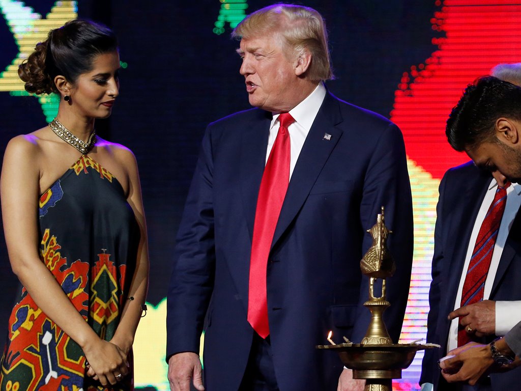 Republican presidential nominee Donald Trump (C) gets help lighting a ceremonial diya lamp before he speaks at a Bollywood-themed charity concert put on by the Republican Hindu Coalition in Edison, New Jersey, U.S. October 15, 2016. Reuters/Jonathan Ernst