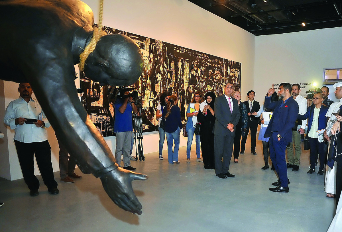 Journalists look at an exhibit by Iraqi-Canadian artist Mahmoud Obaidi at Katara yesterday. Pic: Baher Amin/ The Peninsula