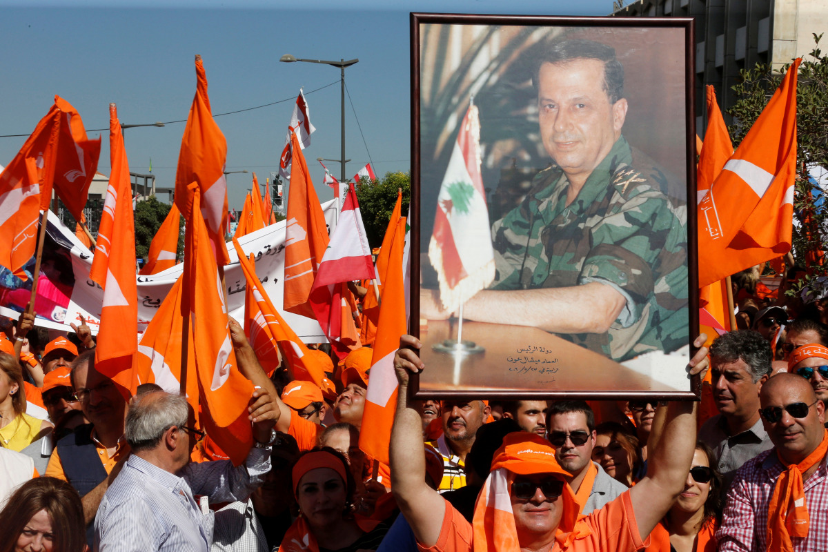 Supporters of the Free Patriotic Movement (FPM) carry flags and a picture of Christian politician and FPM founder Michel Aoun during a rally to show support for Aoun and calling to elect a president, near the presidential palace in Baabda, near Beirut, Le