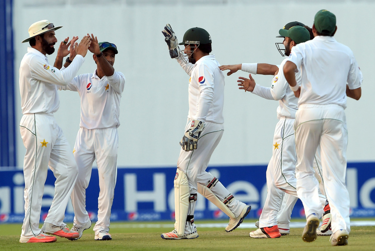 Pakistani cricket captain Misbah-ul-Haq (L) celebrates with teammates after the dismissal of the West Indies' batsman Kraigg Brathwaite on the second day of the second test between Pakistan and West Indies at the Sheikh Zayed Cricket Stadium in Abu Dhabi 