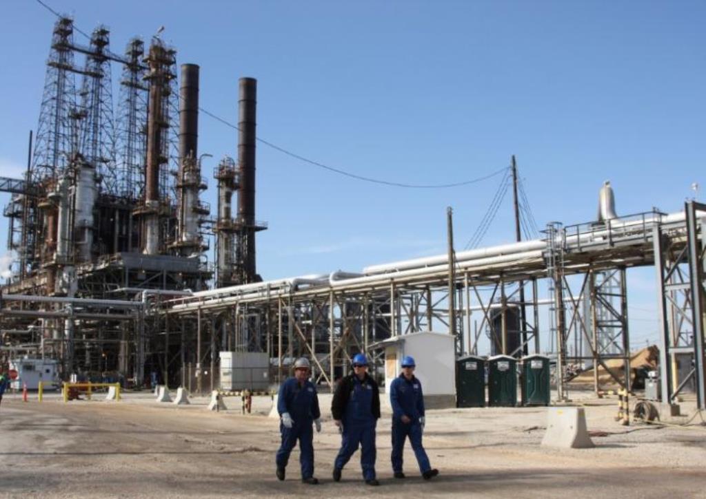 Refinery workers walk inside the LyondellBasell oil refinery in Houston, Texas March 6, 2013. Reuters/Donna Carson/File Photo