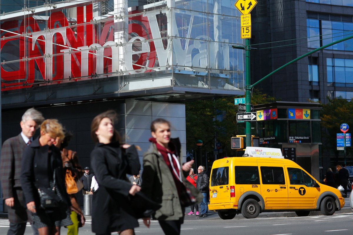 Pedestrians walk past the Time Warner Inc. Center in New York on October 23, 2016. AT&T unveiled a mega-deal for Time Warner that would transform the telecom giant into a media-entertainment powerhouse positioned for a sector facing major technology chang