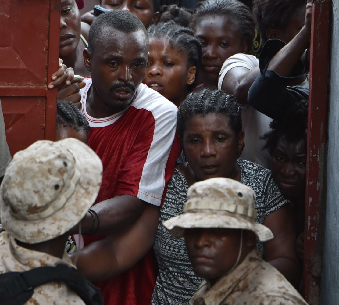 Residents await their turn to obtain food and zinc sheets for roofing at a local distribution center in the city of Jeremie, southwestern Haiti, on October 22, 2016, in the aftermath of Hurricane Matthew. AFP / Hector Retamal