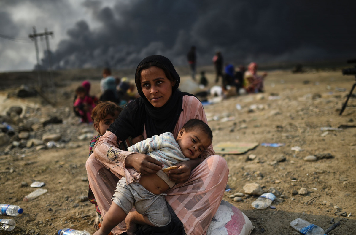 Iraqi families who were displaced by the ongoing operation by Iraqi forces against jihadistds of the Islamic State group to retake the city of Mosul, are seen gathering in an area near Qayyarah on October 24, 2016. The UN refugee agency is preparing to re