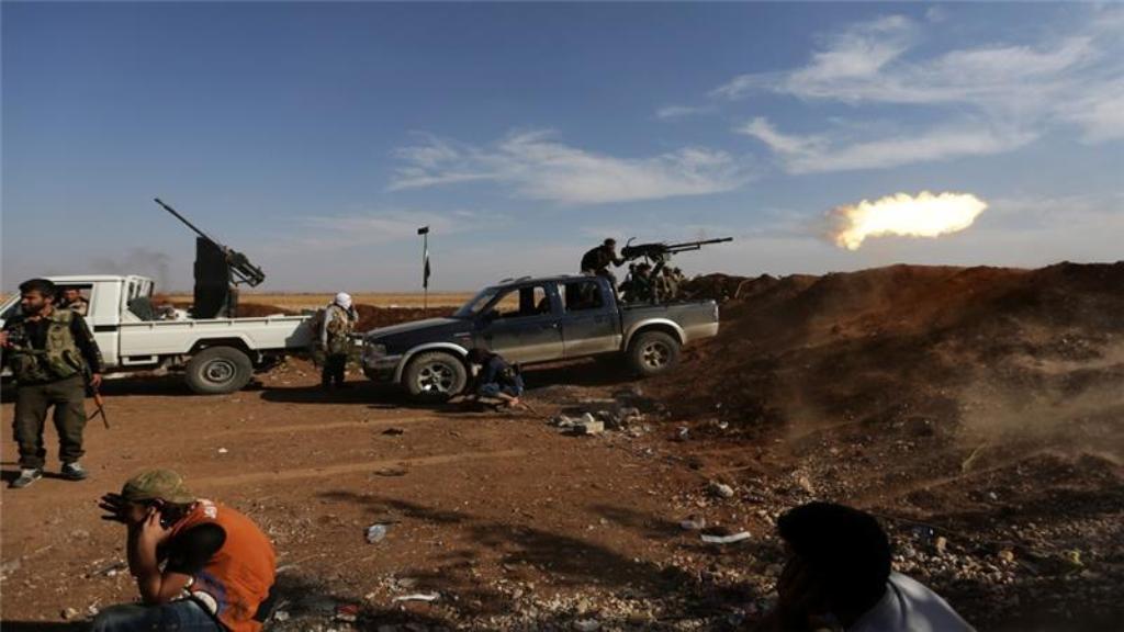 A Turkey-backed rebel fighter in Marea shoots towards Syria Democratic Forces (SDF) in Tel Rifaat [Khalil Ashawi/Reuters]