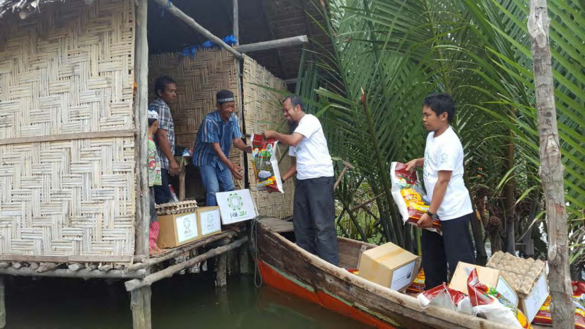Representatives from RAF carrying food items in a boat for distribution to poor people in an Island in Indonesia.