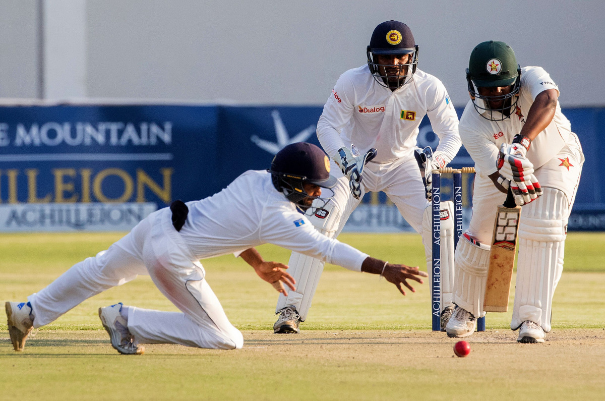 Zimbabwe's batsman Tinotenda Mawoyo plays a shot in front of Sri Lanka's wicketkeeper Kusal Janith Perera during the second day's play in the first cricket Test match between Sri Lanka and hosts Zimbabwe at the Harare Sports Club on October 30 2016. This 