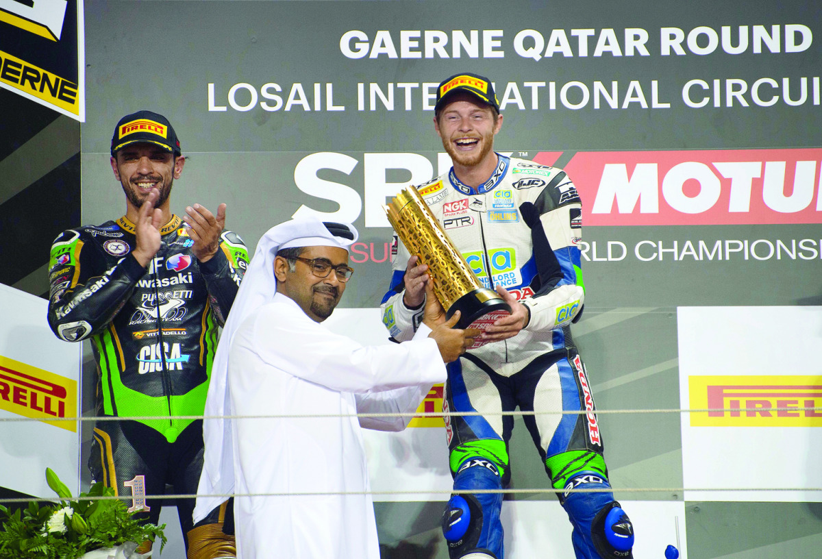 British rider Kyle Smith of CIA Landlord Insurance Honda Team receives the winner's trophy from QMMF President Abdulrahman Al Mannai during the presentation ceremony at the Losail International Circuit yesterday.