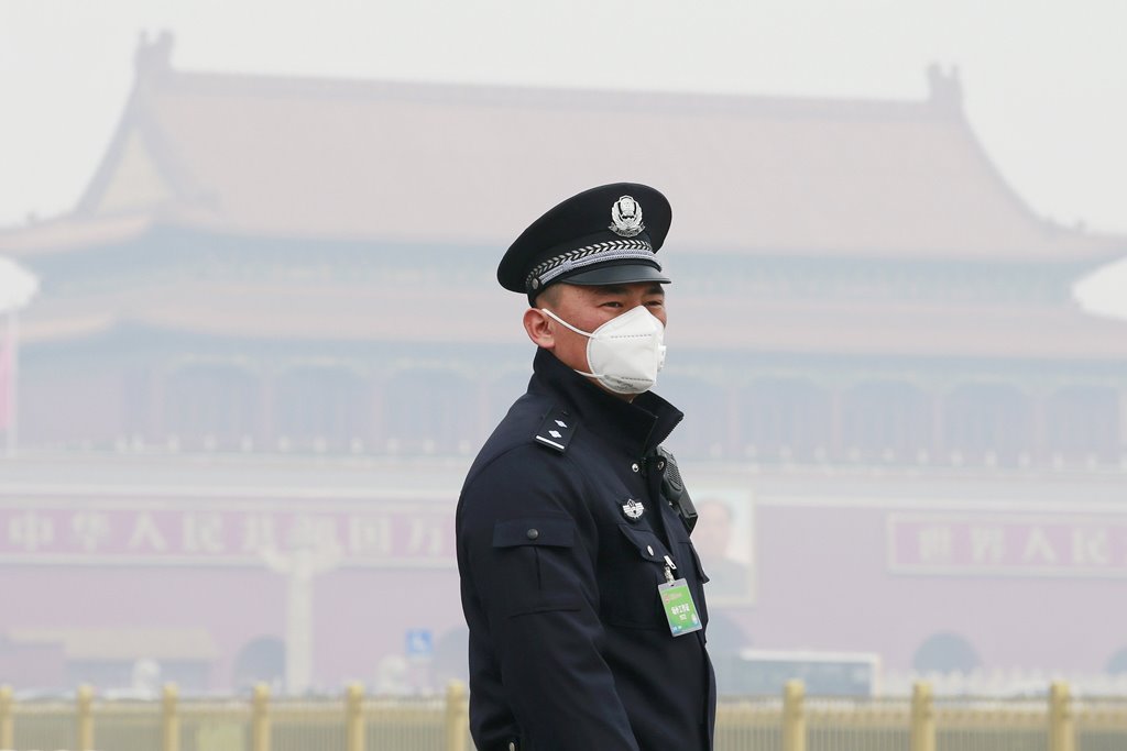 A policeman, wearing a mask to protect from severe pollution, secures the area near the Great Hall of the People before the opening session of the Chinese People's Political Consultative Conference (CPPCC) in Beijing, China, March 3, 2016. REUTERS/Kim Kyu
