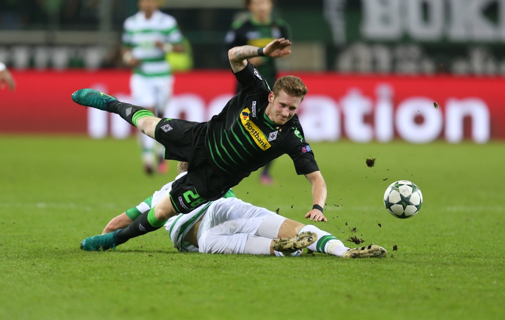 Andre Hahn (L) of Moenchengladbach challenges Stuart Armstrong of Celtic Glasgow during the UEFA Champions League group C soccer match between Borussia Moenchengladbach and Celtic Glasgow at the Borussia Park stadium in Moenchengladbach, Germany on Novemb