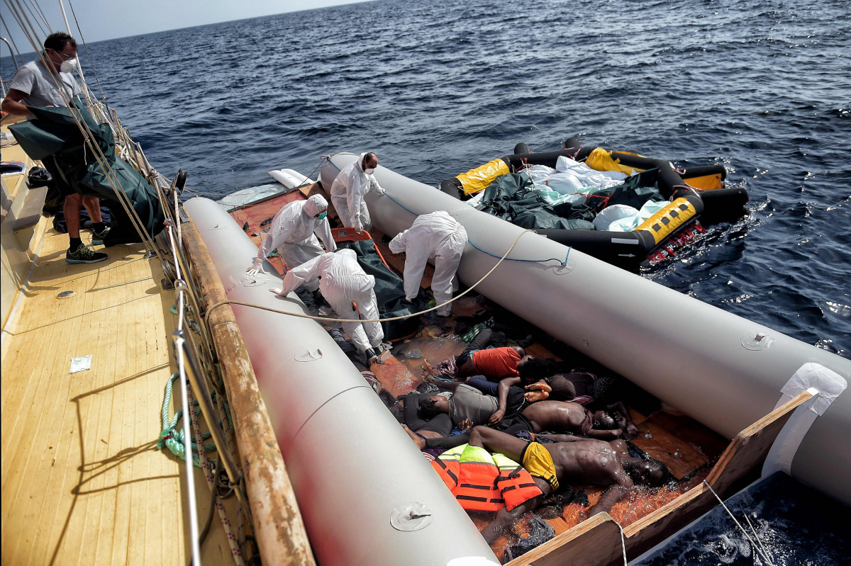 Members of Spanish humanitarian NGO Proactiva Open Arms, carry corpses of migrants after a rescue operation off the coast of Libya on October 4, 2016. The non-profit group, originally created by Spanish lifeguards in 2015 to save refugees and migrants try