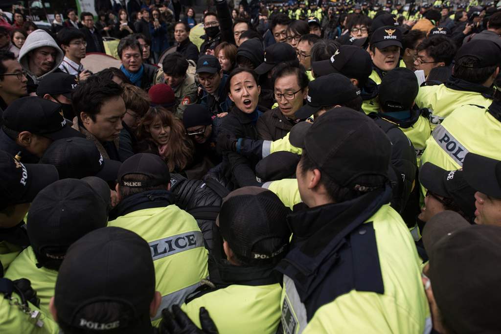 A group of artists clash with police during an anti-government demonstration calling for the resignation of South Korea's president Park Geun-Hye, in central Seoul on November 4, 2016. AFP / Ed Jones