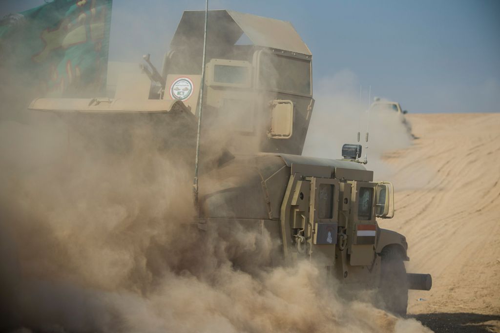 A convoy of the Iraqi army's 9th armoured division drives through an open field to approach the eastern Al-Intissar neighbourhood of Mosul on November 6, 2016, during a military operation to retake the main hub city from the Islamic State (IS) group jihad