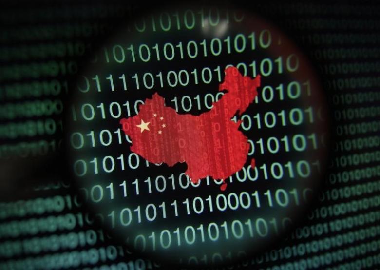 A map of China is seen through a magnifying glass on a computer screen showing binary digits in Singapore. Reuters