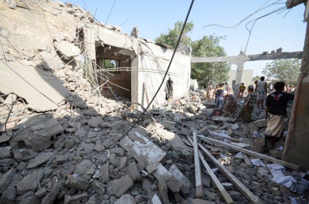 People stand on the rubble of a prison struck by Arab coalition warplanes in al-Zaydiyah district of the Red Sea port city of Hodeidah, Yemen Oct. 30, 2016. / Reuters.