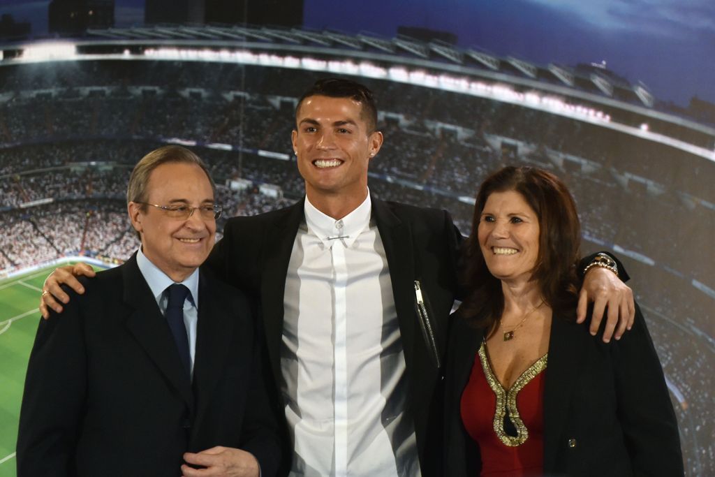 Real Madrid's Portuguese forward Cristiano Ronaldo (C) club president Florentino Perez and Portugal's forward Cristiano Ronaldo's mother Maria Dolores dos Santos Aveiro (R) pose during the official presentation of Ronaldo's contract renewal, in the presid