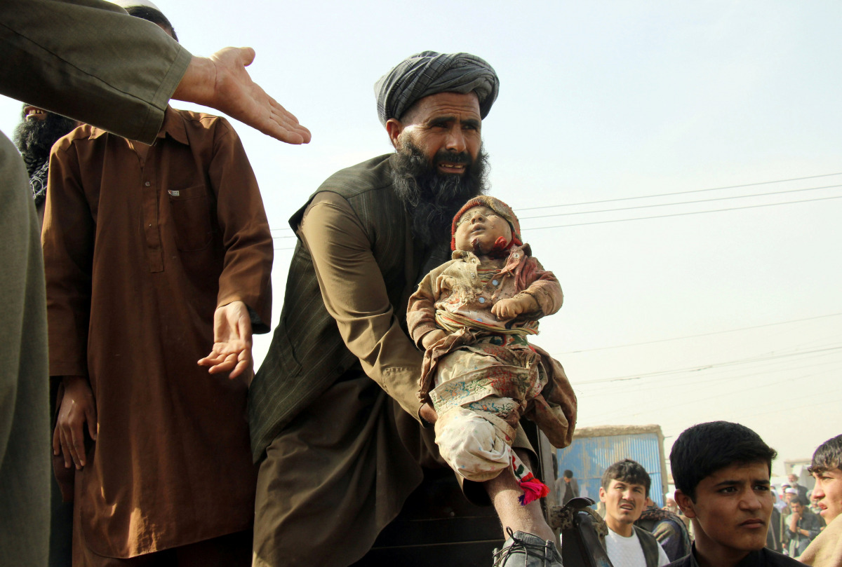 An Afghan man holds up the dead body of a child who was killed by an air strike called in to protect Afghan and U.S. forces during a raid on suspected Taliban militants, in Kunduz, Afghanistan November 3, 2016. REUTERS/Nasir Wakif