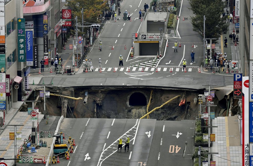 A huge sinkhole is seen at an intersection near Hakata station in Fukuoka, Japan, November 8, 2016 in this photo taken by Kyodo. credit Kyodo/via REUTERS 