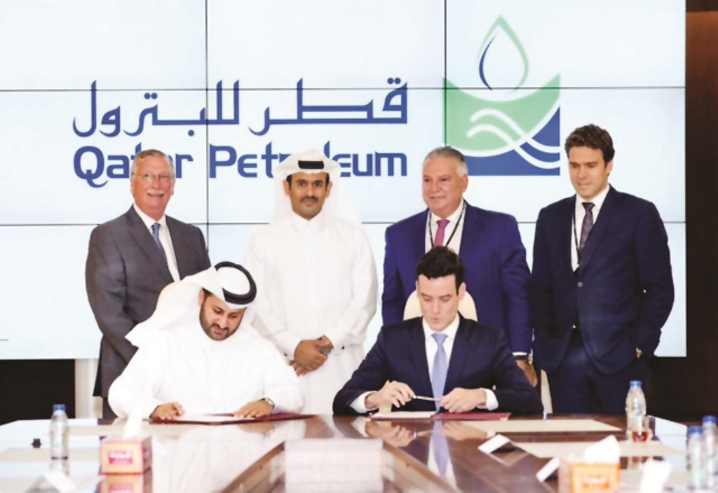 Saad Sherida Al-Kaabi (standing second left) and other officials witnessing the signing ceremony.