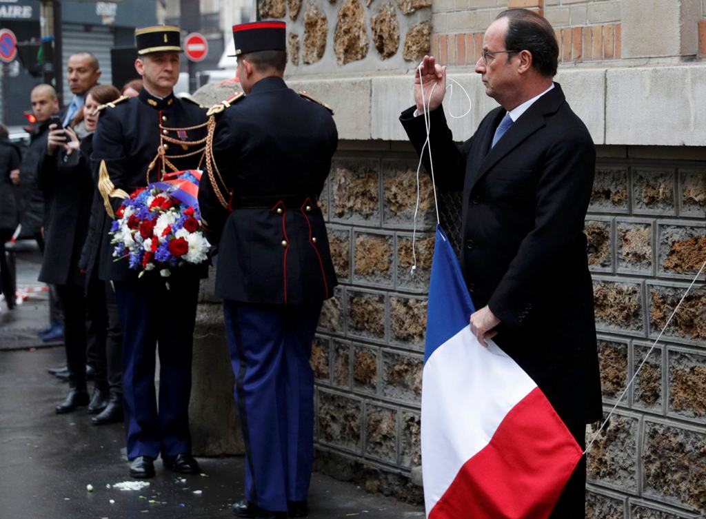 French President Francois Hollande unveils a commemorative plaque next to the 