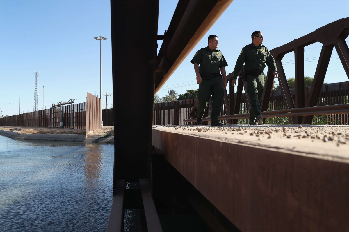  U.S. Border Patrol agents walk over a canal of water flowing into Mexico at the U.S.-Mexico border fence on November 17, 2016 in San Luis, Arizona. The U.S. government has built triple fencing to deter illegal immigrants and smugglers who previously easi
