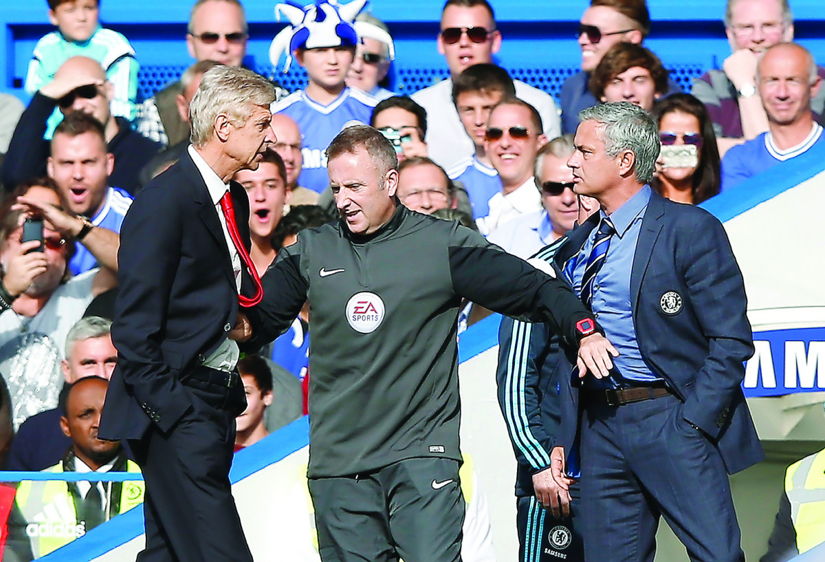 Chelsea's manager Jose Mourinho (Right) and Arsenal's manager Arsene Wenger (left) being kept apart by the fourth official referee during their Premier League match at Stamford Bridge in London, England in this October 5, 2014 file Photo. 
