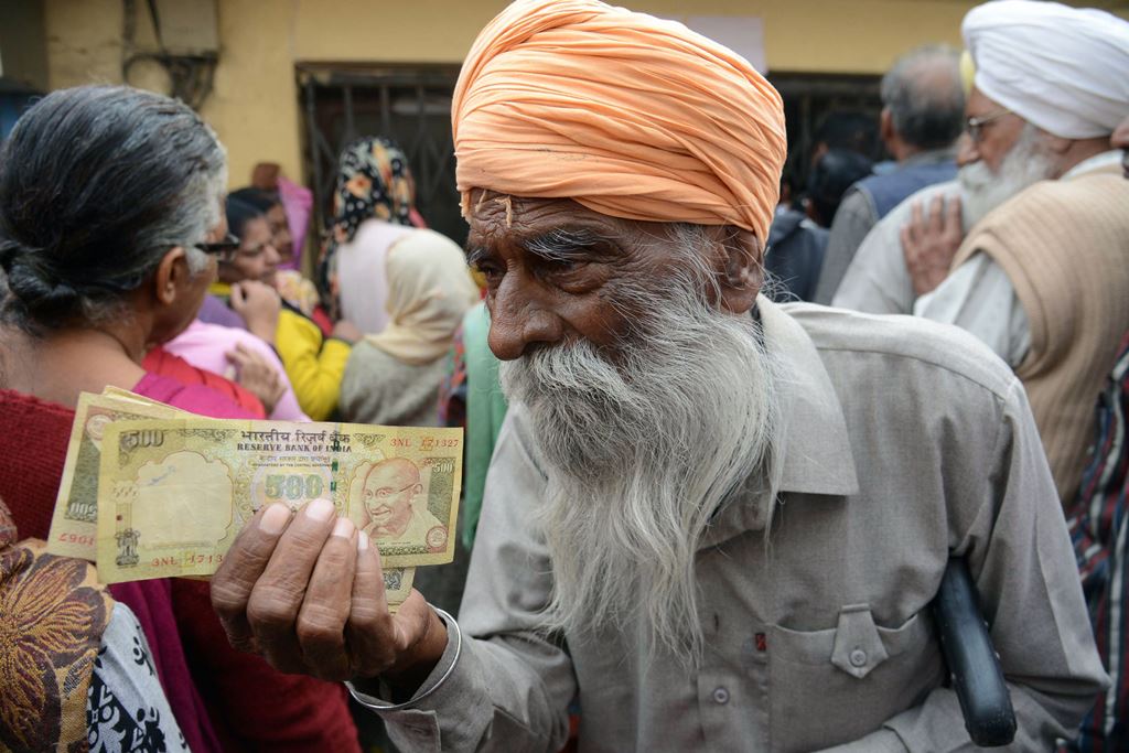 Indian senior citizens gather outside a bank as they wait to deposit and exchange 500 and 1000 rupee notes in Amritsar on November 19, 2016. AFP / NARINDER NANU