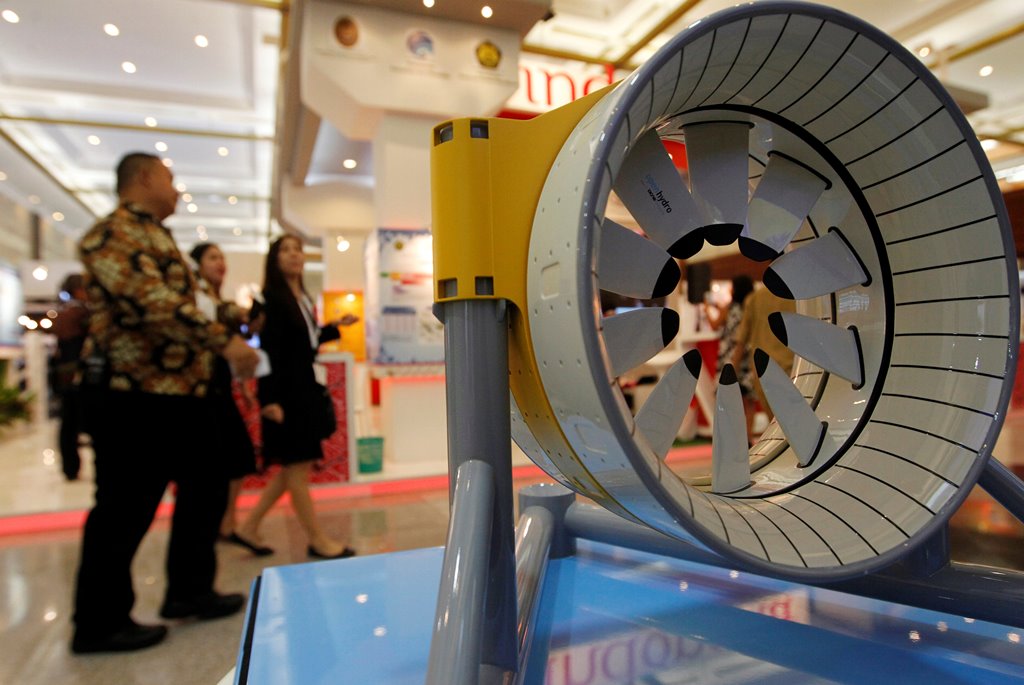 People walk past a model of marine turbine for generating electricity from underwater tidal streams, at an infrastructure expo in Jakarta, Indonesia, November 11, 2016. Picture taken November 11, 2016. REUTERS/Iqro Rinaldi