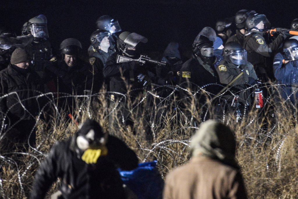 Police confront protesters with a rubber bullet gun during a protest against plans to pass the Dakota Access pipeline near the Standing Rock Indian Reservation, near Cannon Ball, North Dakota, U.S. November 20, 2016. REUTERS/Stephanie Keith 
