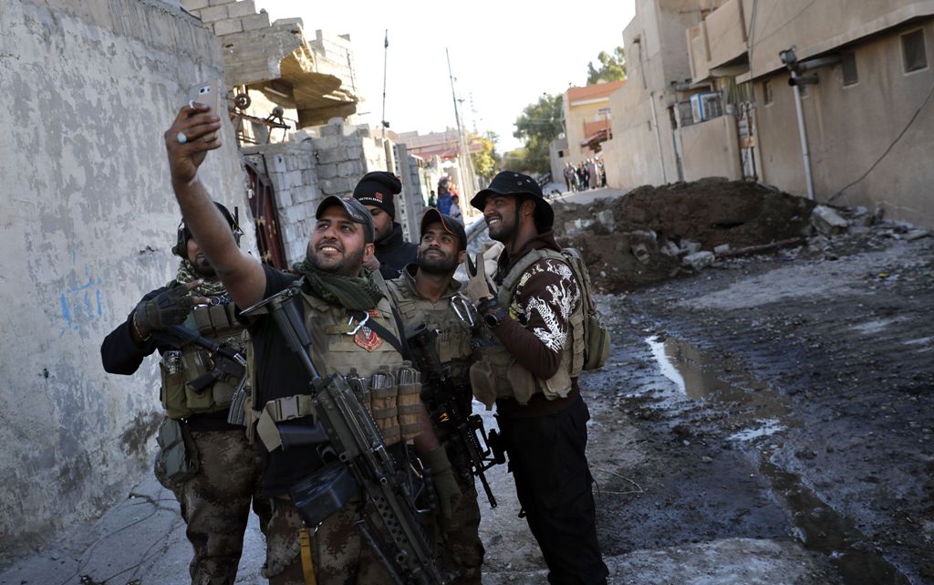  A soldier from the Iraqi Special Forces takes a selfie on a street in the Aden district of Mosul after troops almost entirely retook the area from Islamic State (IS) group jihadists on November 22, 2016.  AFP / THOMAS COEX
