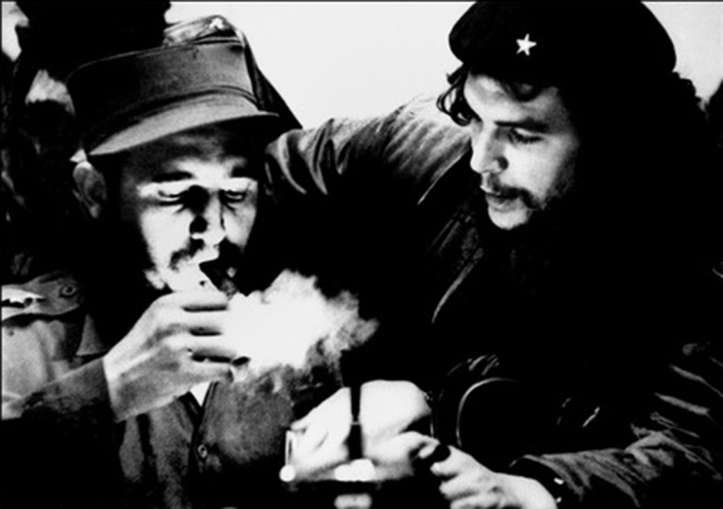 (FILES) This file photo taken in the 60s shows then Cuban Prime Minister Fidel Castro (L) lighting a cigar while listening to Argentine Ernesto Che Guevara. Cuban revolutionary icon Fidel Castro died late on November 25, 2016 in Havana, his brother, Presi