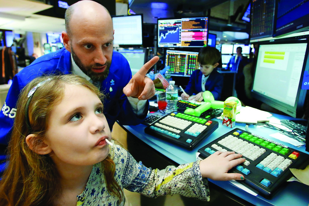 Specialist trader Meric Greenbaum works with his daughter on the floor of the New York Stock Exchange (NYSE) in New York City, U.S., November 25, 2016. REUTERS/Brendan McDermid
